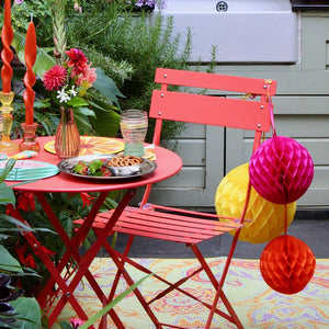 the honeycomb decorations are see in a photo hanging off the side of a garden chair in a sunny garden
