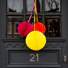 Load image into Gallery viewer, here the three honeycomb ball decorations are photographed hanging on a front door