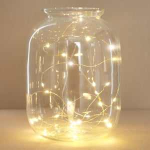 Gold string lights in a glass jar