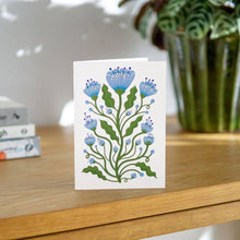 Load image into Gallery viewer, Floral card on a wooden surface with a plant in the background