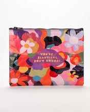 Load image into Gallery viewer, Pouch with zip across the top. The words “you’re beautiful. Don’t change” are in the middle in yellow lettering on a purple background. Around this is a bright floral design.
