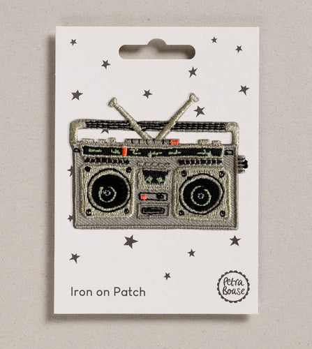 The iron on boombox patch is shown fixed to its backing card which has little stars all over it.