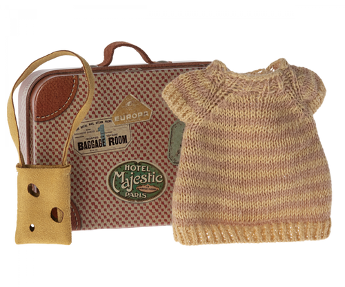A sweet little metal suitcase illustrated to look like an old vintage one with destination stickers.  The knitted dress insied is soft pink and yellow stripes.  the little habdbag is a natural sand colour with little holes in it like a dutch cheese.