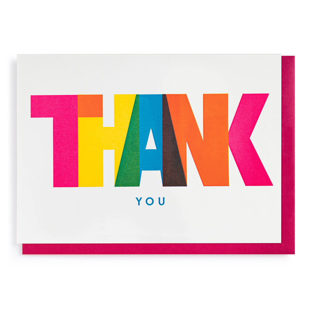 Bright, colourful, striking, thank you card.  The word THANK is printed in bright colours, each letter a differnt one.  the letters and the colours slightly overlap, eg the yellow H and the blue A create a green overlap. underneath in much smaller capitals is the word YOU in bright blue.