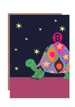 Load image into Gallery viewer, 8th birthday card featuring a brightly coloured tortoise balancing a pink ball on its back with the number 8 on it.  The background is black with yellow stars.