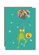 Load image into Gallery viewer, This 6th birthday card by Hutch Cassidy featured a smiling frog in a striped party hat being held aloft by a large bunch of multicoloured balloons he is holding.  The background is bright turquoise and the number 6 is prominently seen in a large yellow circle