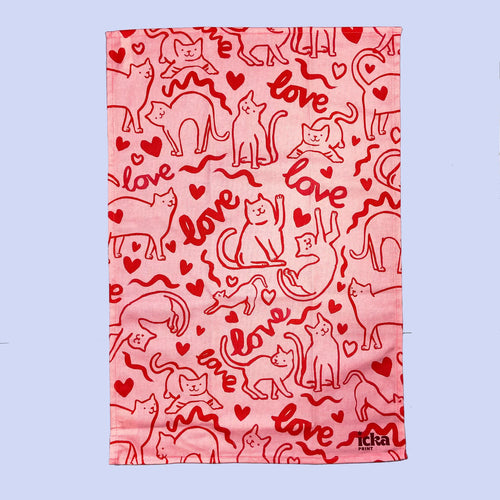 Pink tea towel with an outline of cats the word love 