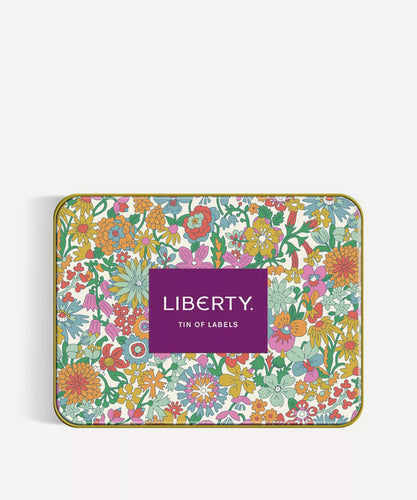 Liberty floral print tin with “Liberty Tin of Labels” printed in the middle in a purple rectangle.