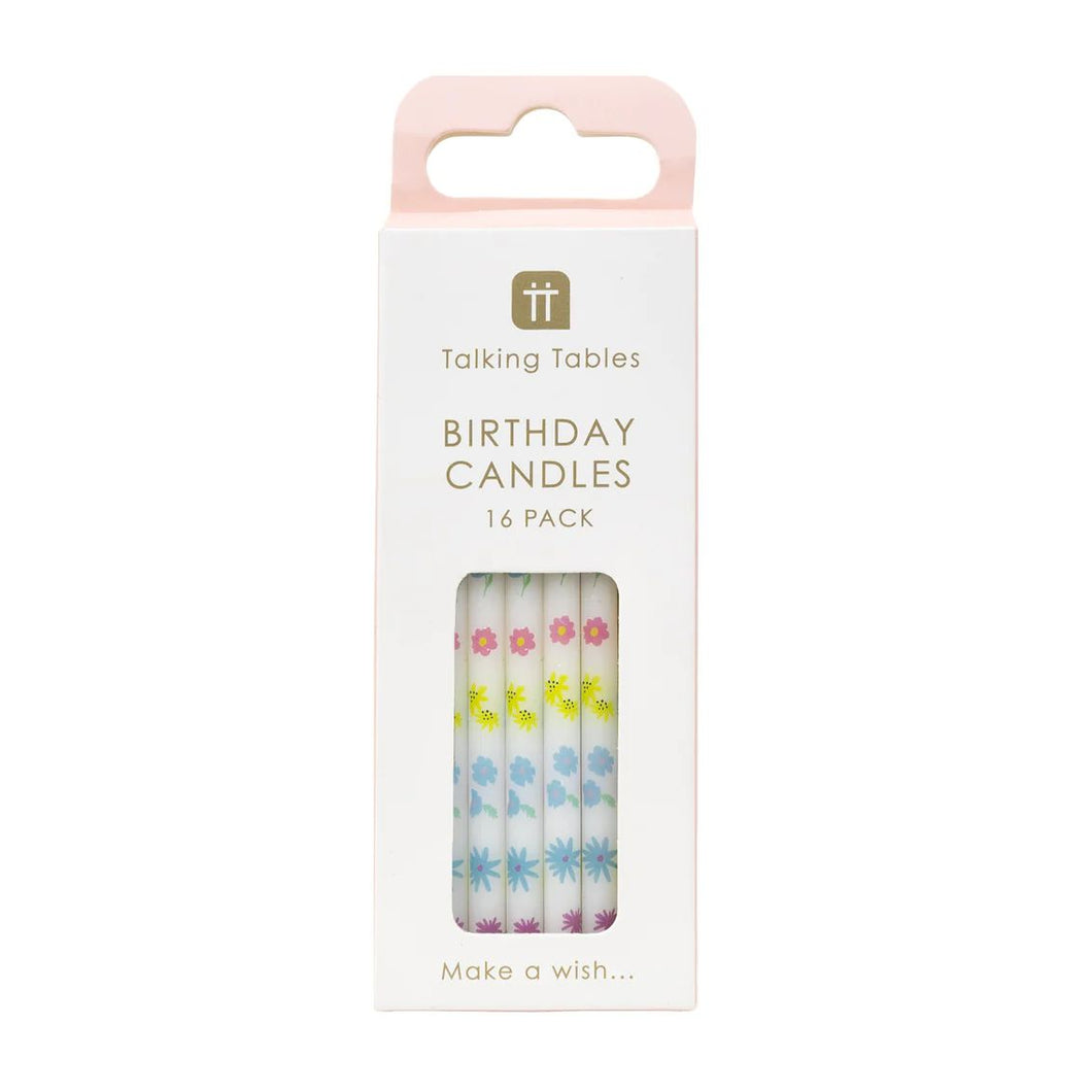 cake candles in their white cardboard packaging.  A cut out window allows you to see the little white cake candles with pastel coloured flowers in purple, blues, pink and yellow running up their length.