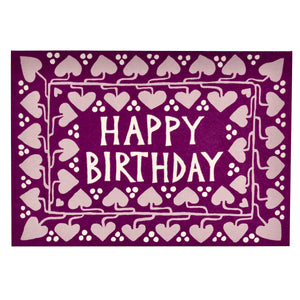 Beautiful card by Cmbridge Imprint with a dark purple background and a vine of paler purple hearts design all around the card, with the hand designed lettering  in white reading "HAPPY BIRTHDAY" in the centre