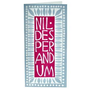 This unusual long card by cambridge imprint has a dark pink centre with white, large, capial lettering down the centre "NIL.DESPERANDUM"  As the lettering is so large only 3 letters fit into each line.  Around this the card has a blue and white design of simple leaf like shapes and dots.