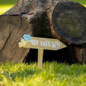shows one of the little sign posts placed in a garden.  It reads "Not this Way."