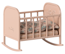 Load image into Gallery viewer, A light pink metal cradle with stripey matress and floral duvet and pillow in muted colours
