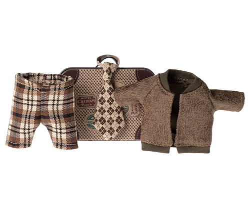 little metal suitcase in the style of a vintage one with destination and hotel stickers. The clotes include a check brown and beige wide tie, Brown tartan check trousers and a brown fleecy jacket.