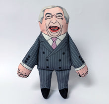Load image into Gallery viewer, Nigel Farage squeaking Dog Toy by pet hates, wearing a grey double breasted pin stripe suiit and his face is printed, with characteristic wide mouth self satisfied smile.

