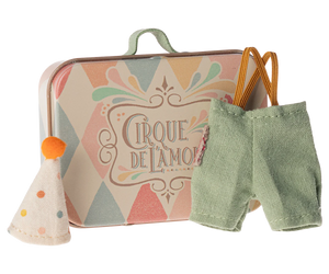 little metal suitcase with harlequin design in pastel colours and the words "Cirque De L'Amour".  The tiny clothes are little pale turquoise trousers brown elastic braces and a spotty pointed hat with a little orange pom pom on top.