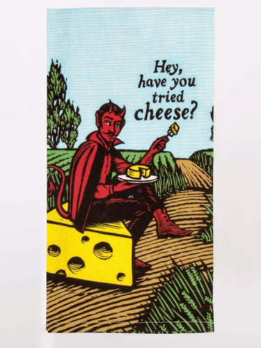 The red devil is sitting on a large chunk of holey cheese on a country path.   He is holding a plate of cheese and has a chunk on a fork whichbhe is offering. The words are printed on the blue sky “hey, have you tried cheese?”.