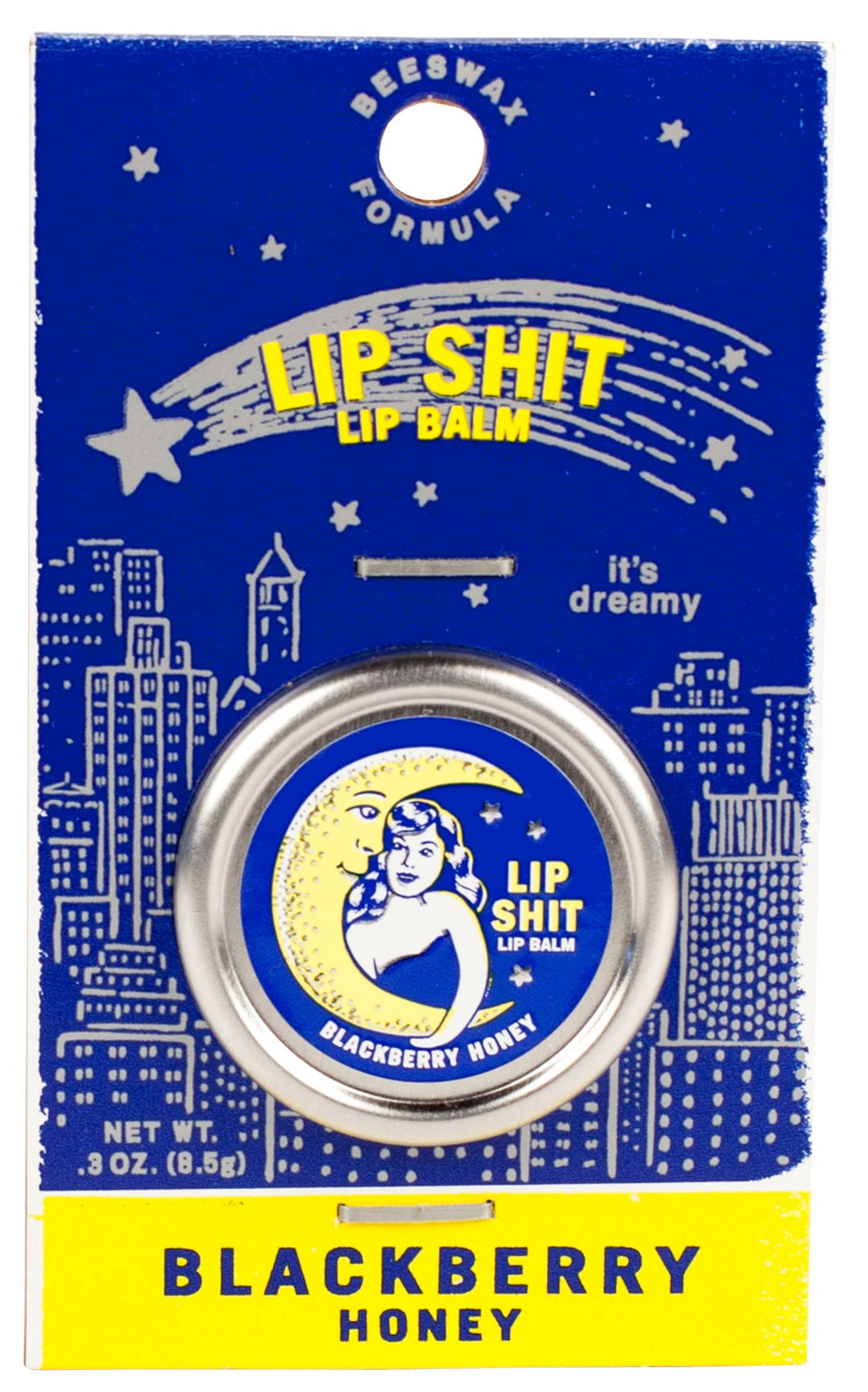 A silver tin of 'lip shit' lip balm with a picture of a moon embracing a woman. Tin is backed on a navy blue card with a simple outline of a starry city skyline. Fonts are contrasting navy and bright yellow.