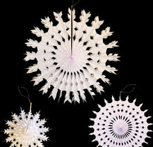 Load image into Gallery viewer, Three white paper hanging snowflake decorations of different sizes and designs, displayed against a solid black background.
