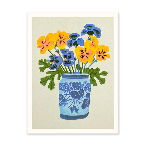 soft white background, blue and white vase with blue and yellow pansies