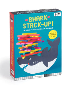 Blue box with a grey shark balancing a pile of different brightly coloured wooden sticks on his nose 