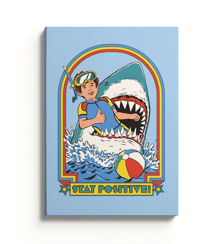 The front cover of this notebook has abrightly coloured design featuring a smiling boy in snorkelling gear smiling and with his thumb up, in the mouth of a giant shark.  Under this image is the words STAY POSITIVE!