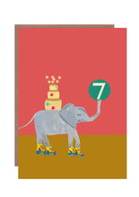 Load image into Gallery viewer, This 7th birthday card by Hutch Cassidy features an elephant on roller skates with a large tired birthday cake on its back and a large green hall with the number 7 is carried aloft by its trunk.
