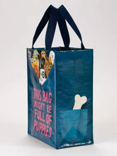 Load image into Gallery viewer, Bag Full of Puppies Lunch Bag Handy Tote by Blue Q | £8.99. Cute little tote bag by blue Q featuring an illustration by John Bond. The bag is mostly dark petrol blue with bright pink lettering which reads “THIS BAG MIGHT BE FULL OF PUPPIES”. At the top edge of the bag 9 little assorted puppies can be seen, as if they are pulling the rim of the bag down and are inside.

