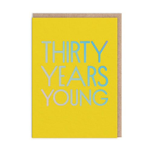 Bright yellow card with large holographic capital letters reading “THIRTY YEARS YOUNG”