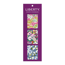 Load image into Gallery viewer, 3 floral rectangular magnetic bookmarks in a vertical line on their purple packaging with Liberty Magnetic Bookmarks printed at top.
