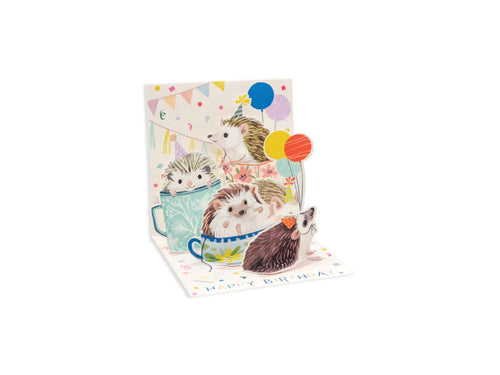 A pop up card with 5 hedgehogs with party hats and balloons in tea cups