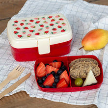 Load image into Gallery viewer, Red bento box with strawberry pattern lid, filled with fruits and bread, on a checkered cloth.
