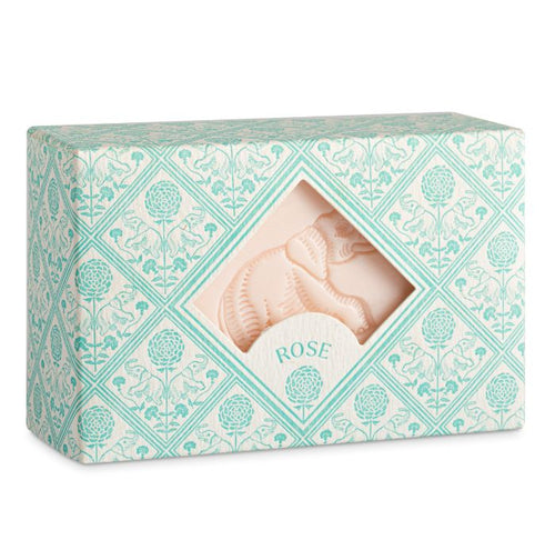 the packaging of the box has a pale blue and white, tile design of eleohants and flowers.  There is a centrail diamond shape cut out through which the pale pink soap with an embossed elephant design can be seen