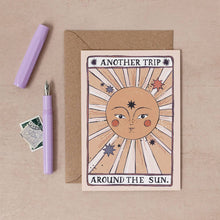 Load image into Gallery viewer, The words &#39;Another trip around the sun&#39;  surrounding illustration of shining sun with delicate facial features
