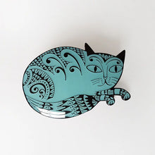 Load image into Gallery viewer, Blue enamel pin badge in the shape of a cat, ilustrated with black swirly designs. The badge is fastened to a light green card
