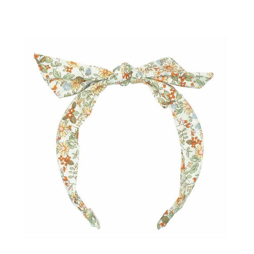 a headband covered in a material with a floral print on it. the material is in a hand tied bow at the top.