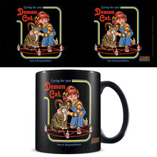 Load image into Gallery viewer, A black ceramic mug with a 1970's style cartoon illustration of a cat and a child sitting in a 5 pointed star, with candles around, with the text 'Caring for your Demon Cat'.

