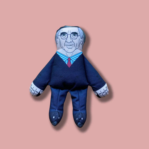 a recognisable squeaky dog toy in the form of jacob Rees Mogg wearing a navy suit and red tie