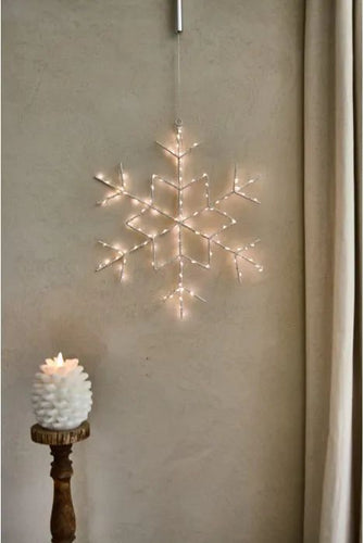 white fairy lights in a snowflake shaped hanging ornament 