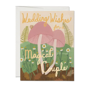 A wedding card featuring a couple of beautifully illustrated magic mushrooms.  it reads "wedding wishes for a magical couple" in gold lettering.  Illustrated by Kate Pugsley for Red Cap cards