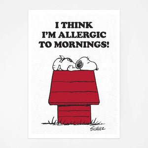 The tea towel features an illustration of snoopy looking very tired on a dog kennel with the words "I think i'm allergic to mornings!" above