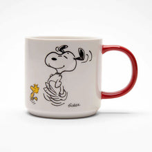 Load image into Gallery viewer, The front of the mug features the Peanut&#39;s character Snoopy dancing. The mug has a red handle.
