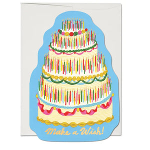 4 layer cake shaped die cut card.  The cake is nicely decorated and has hundreds of multi coloured candles. With gold lettering and candle flames.  Reads "Make a Wish.  Illustrated by Krista Perry for Red Cap Cards, USA.!"