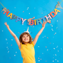 Load image into Gallery viewer, here the bunting is seen behind a young child jumping for joy.  The letters of the bunting are brightly coloured in red, yello, green, blue and pink.  Various animals can be seen along the length including a zebra, giraffe, sloth, crocodile and monkey.  All the aniamals are wearing party hats.
