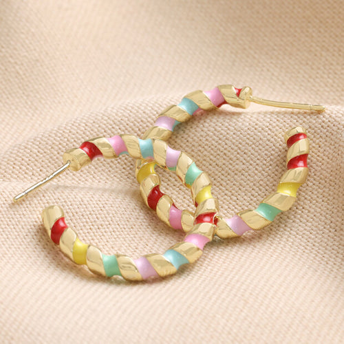 Rainbow Enamel Twist Hoop Earrings in Gold by Lisa Angel | £20.00. A pair of gold hoop earrings with rainbow enamel twists, designed by Lisa Angel. The hoops feature vibrant colours in a twisted pattern, adding a playful and colourful touch to any outfit.