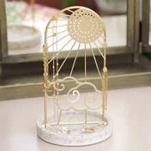 Load image into Gallery viewer, Sunshine Jewellery Stand by Lisa Angel | £22.00. The arched frame is made of gold metal and features a beaming sun design complete with cloud detailing. On the round sun face are holes for studs and hook earrings, while the edge of the frame has pegs made for your necklaces and longer pieces. The base of this stand is made of terrazzo resin in speckled whites, creams and greys to finish this sweet jewellery storage piece. 

