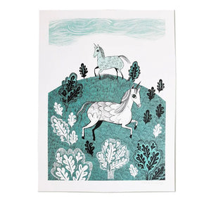 A3 print of two hand illustrated unicorns frollicking on a hil surrounded by oak trees and leaves. The print is in blue and black ink on white card.