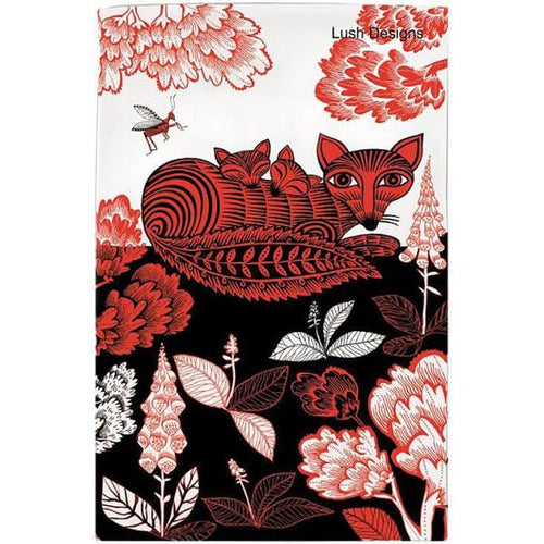 A beautifully designed tea towel featuring a Vixen and her 2 cubs.  The design is in red and black on a white background.  The vixen is lying down surrounded by flowers and trees.  Her cubs are sleeping resting their heads over her back.