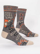 Load image into Gallery viewer, Here Comes Cool Dad Men’s crew Socks by Blue Q | £11.95. Ethical and sustainable socks with quirky, humorous designs and vibrant colours.  This design is in grey featuring a stickman with a thumbs up, abstract patterns and the words “Here comes cool Dad”. Perfect gift for Dads or for Father’s Day. 
