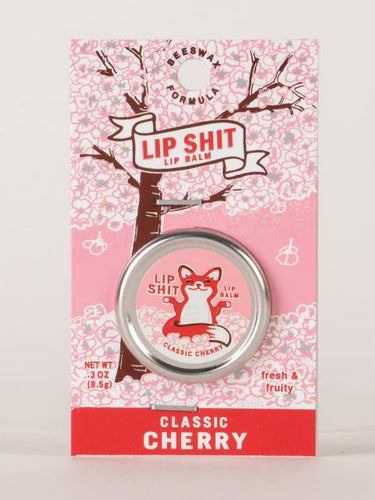 Classic Cherry Lip S**t by Blue Q | £7.50. All natural, vitamin E fortified lip balm. The lip balm is contained within a round metal tin with a sticker on the front depicting sweet fox meditating with the words “Lip Shit”.